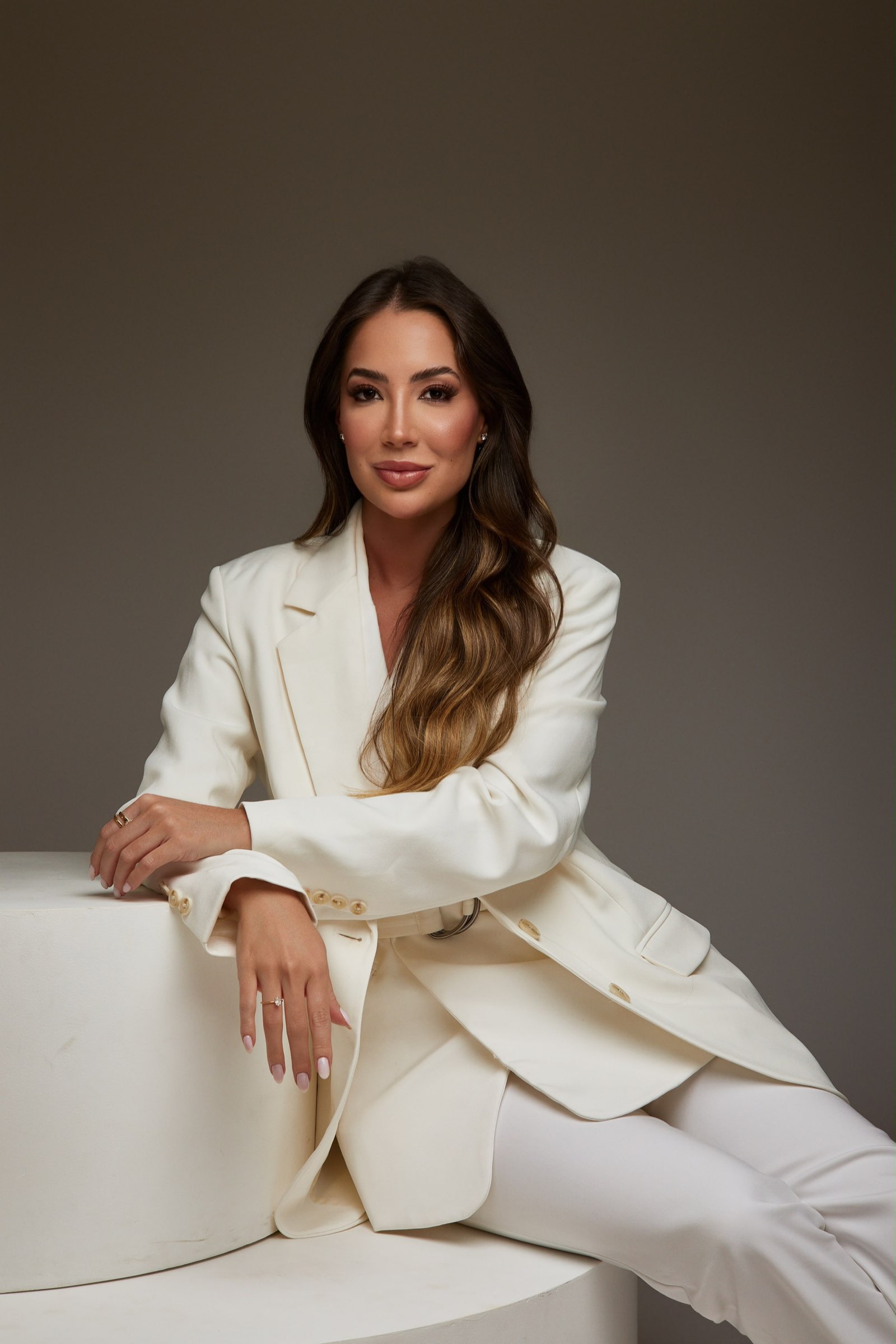 Dra. Julia Lopes sentada, de blazer branco